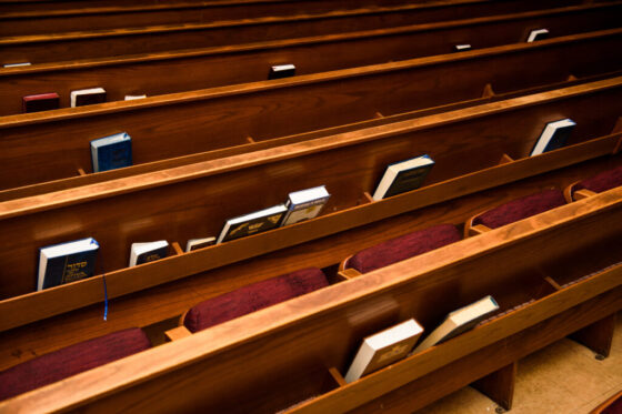 Books stand on shelves on benches in synagogue